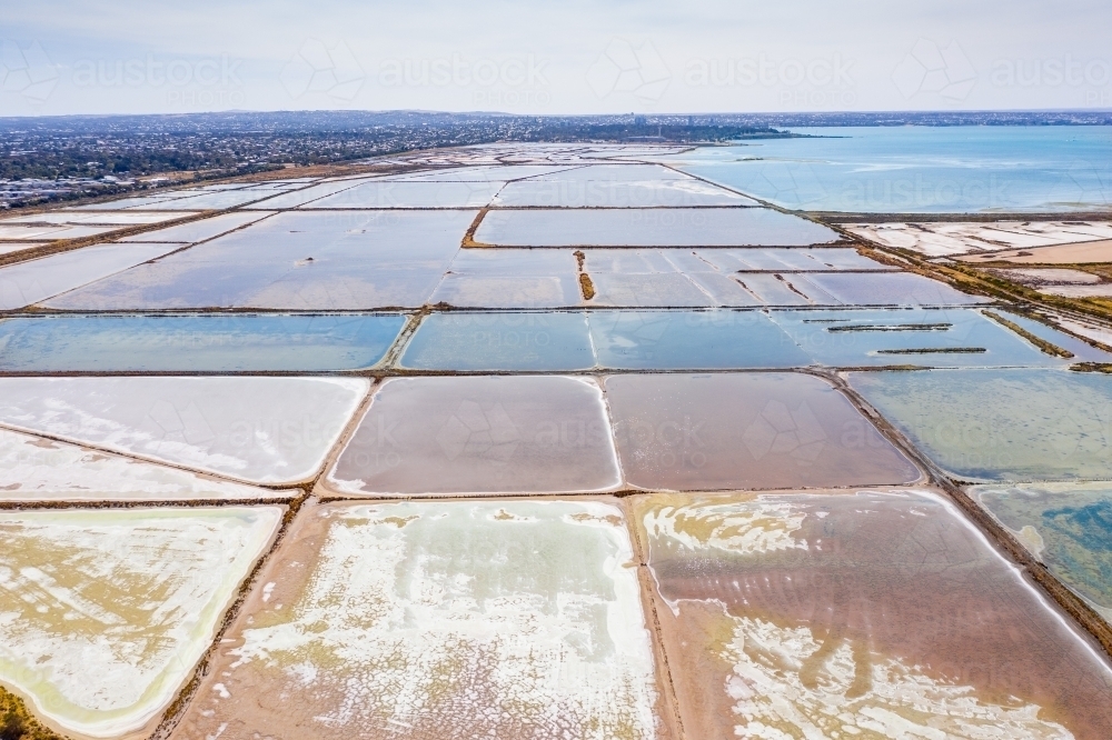 Aerial view of salt evaporation ponds next to a coastal bay. - Australian Stock Image