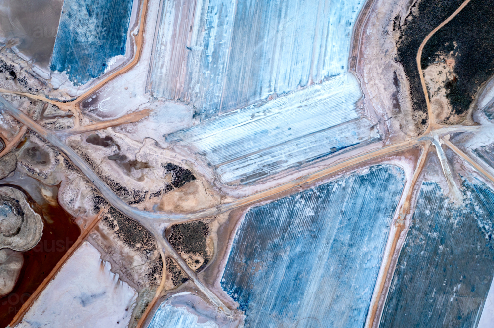 Aerial view of salt evaporation ponds with vivid blue and earthy tones. - Australian Stock Image