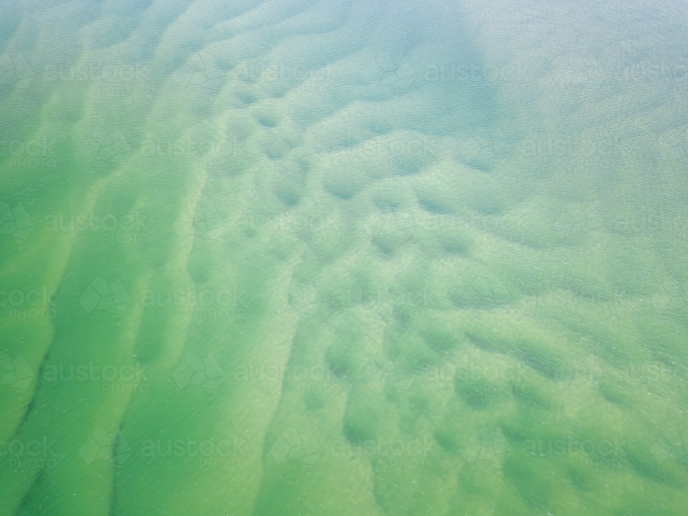 Aerial view of sand patterns in shallow blue water - Australian Stock Image