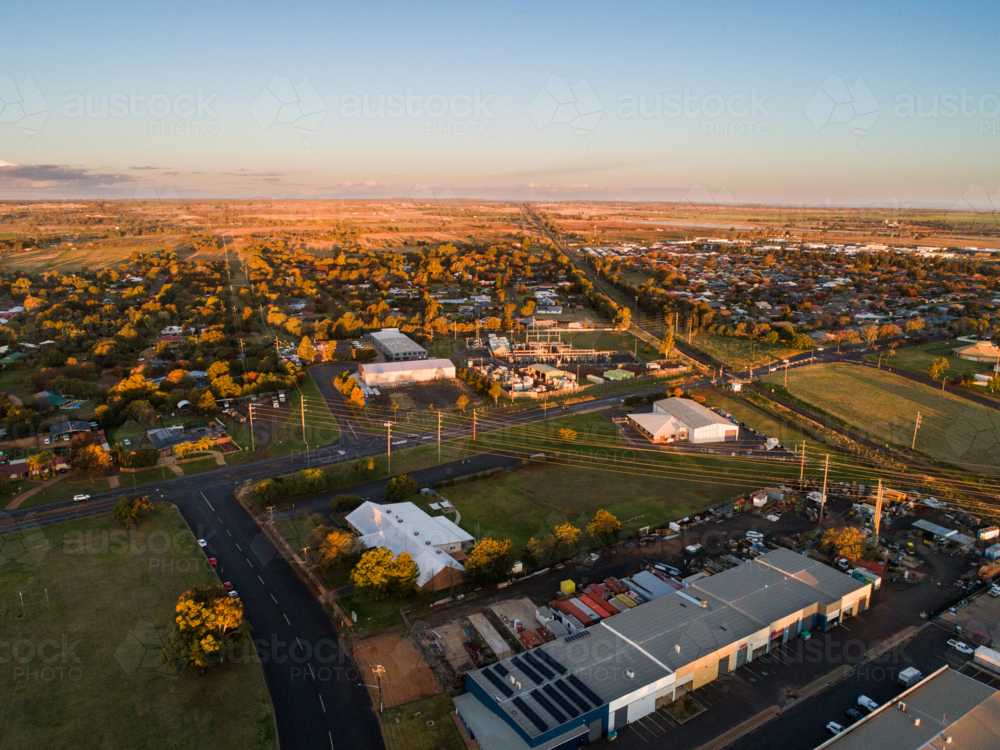 Aerial view of sheds in industrial area in Dubbo at sunset with train line - Australian Stock Image