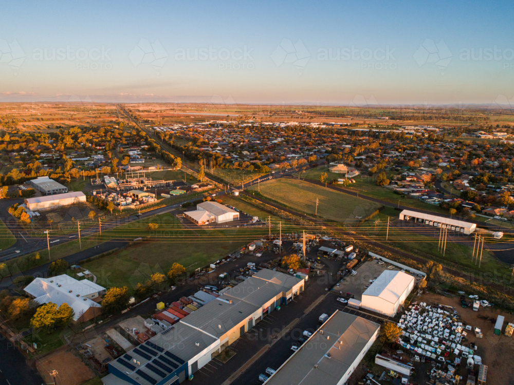 Aerial view of sheds in industrial area in Dubbo at sunset with train line - Australian Stock Image