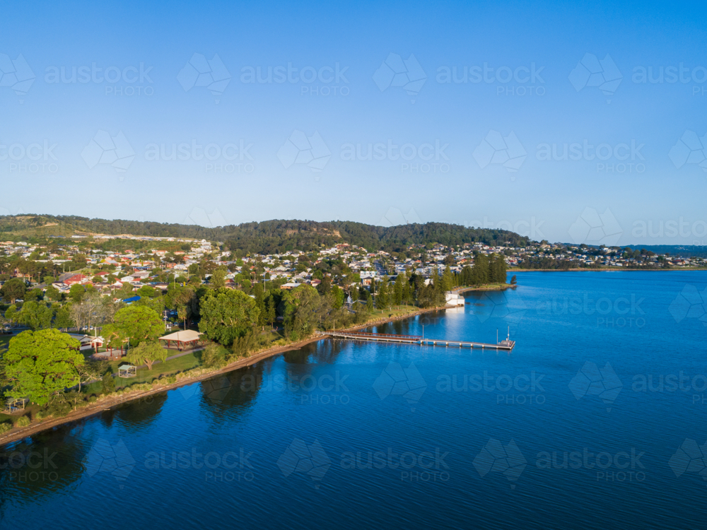 Aerial view of Speers Point Public Jetty in sunlit blue waters of Lake Macquarie and Cockle bay - Australian Stock Image