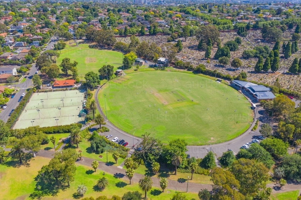 Aerial view of sporting ovals and tennis courts in a city park - Australian Stock Image