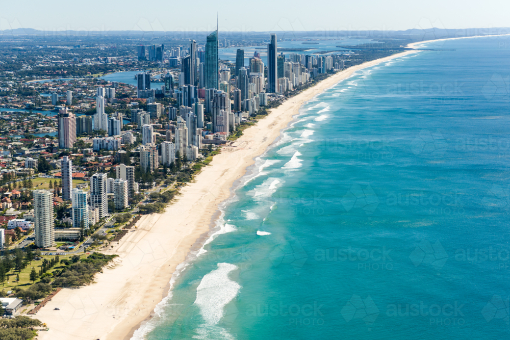Aerial view of Surfers Paradise with high-rise buildings lining a long sandy beach - Australian Stock Image