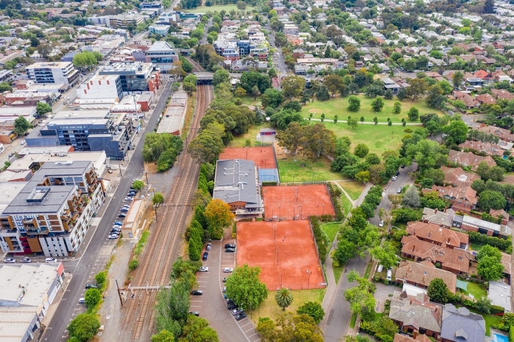 Image of Aerial view of tennis courts and parkland along a railway line
