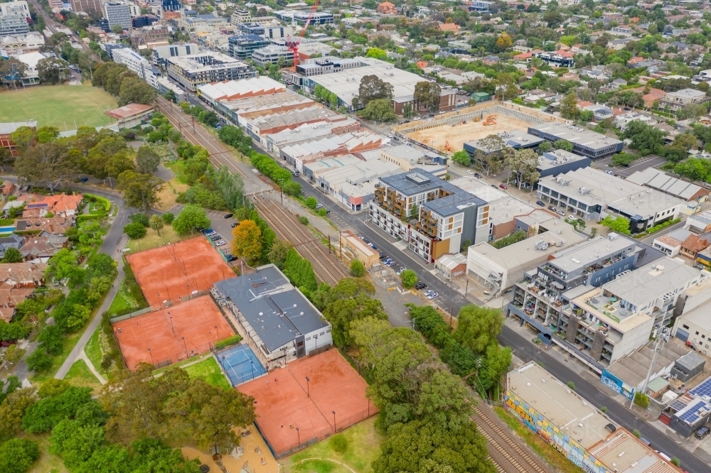 Image of Aerial view of tennis courts and parkland along a railway line
