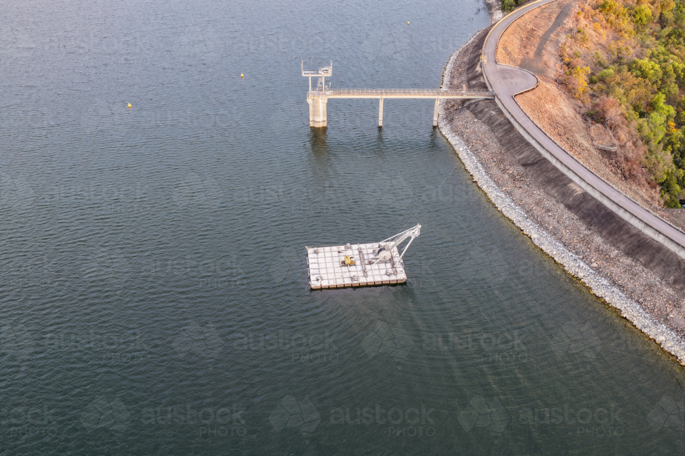 Aerial view of the Glenbawn Dam wall featuring the water intake system and servicing pontoon in NSW - Australian Stock Image