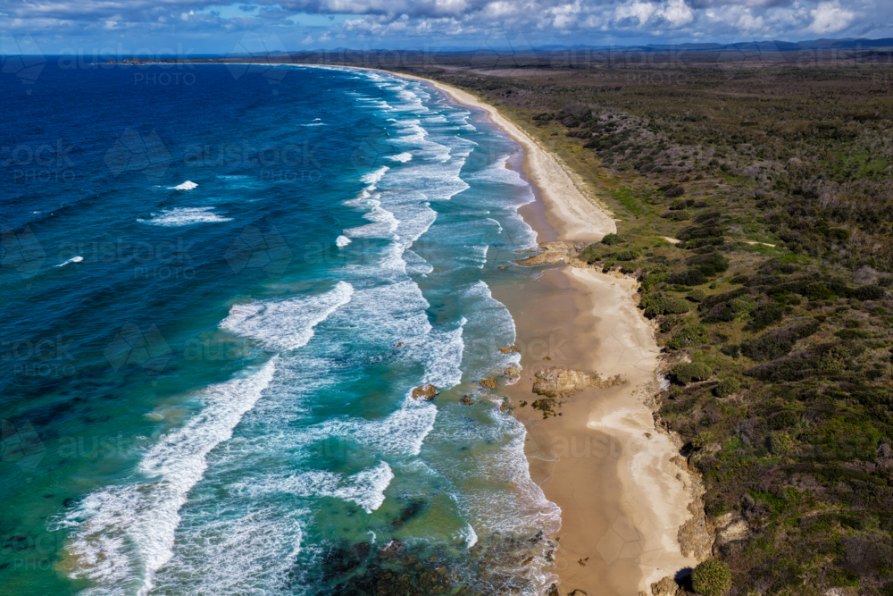 Aerial view of the long sandy shoreline of Sand Dune Beach at Brooms Head - Australian Stock Image