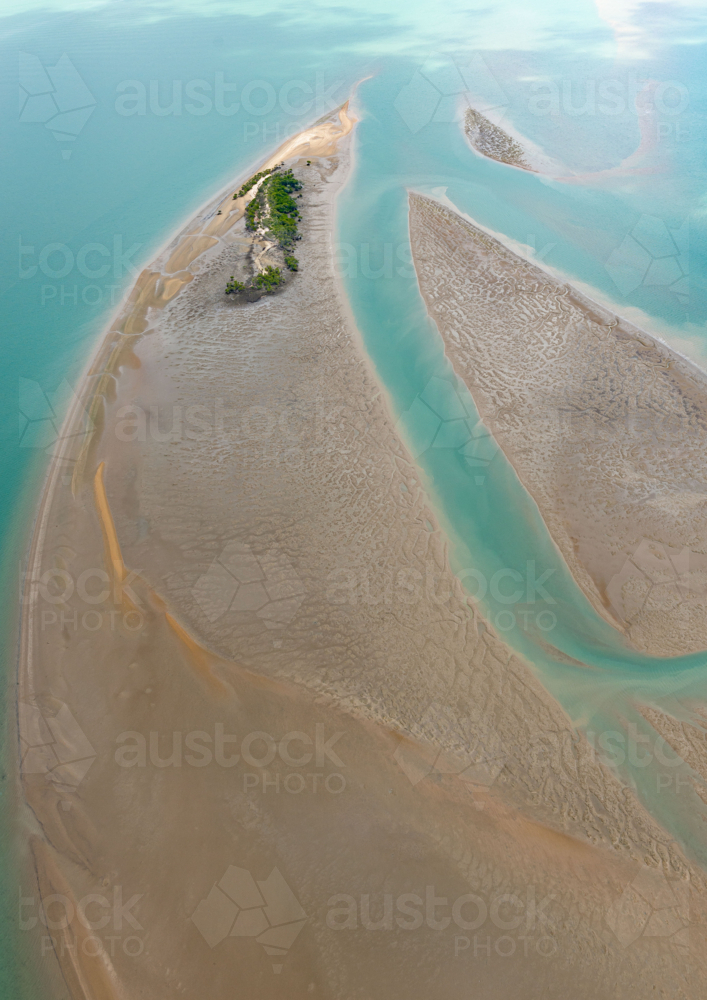 Aerial view of tidal sand flats and green cay amidst clear turquoise sea channels - Australian Stock Image