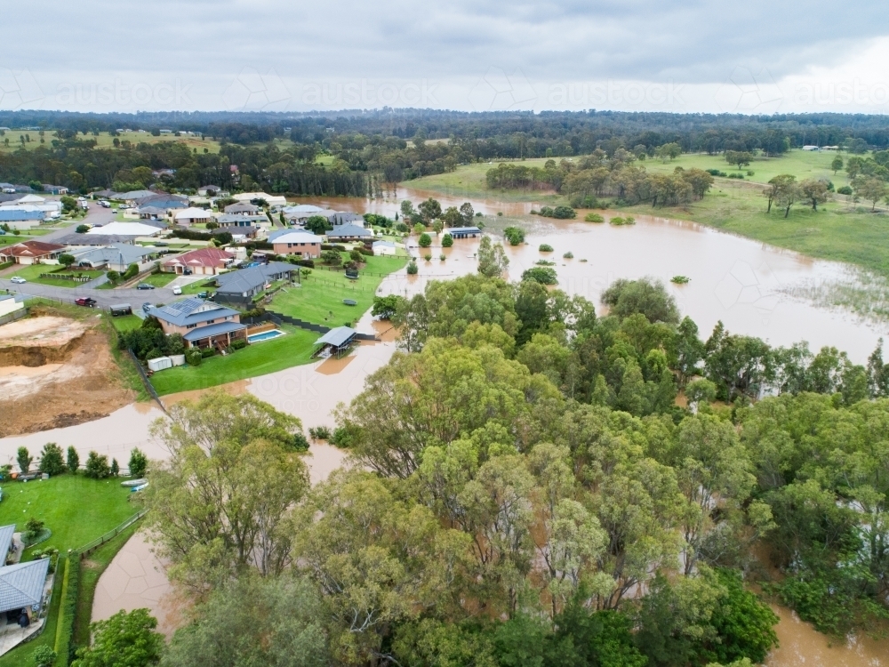 Aerial view of town in hunter valley with floodwaters from flooding river rising - Australian Stock Image