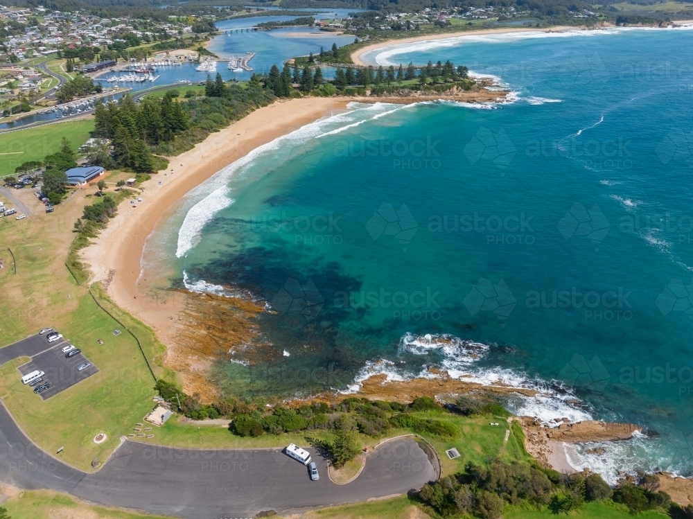 Aerial view of turquoise water in an ocean bay with a golden sand beach - Australian Stock Image