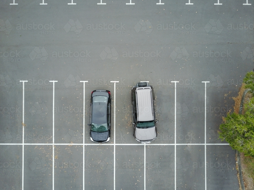 Aerial view of two cars in car park, one of which is over two spaces - Australian Stock Image
