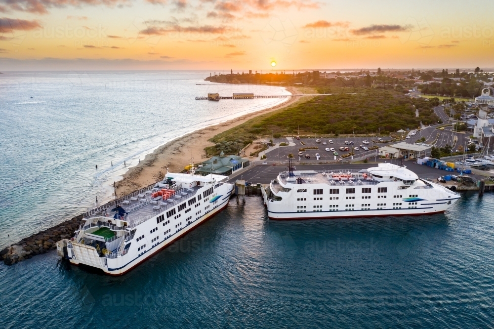 Aerial view of two ferries anchored at a marina at sunset - Australian Stock Image