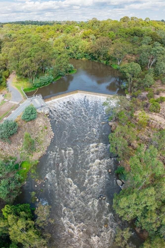 Image of Aerial view of water rushing over a waterfall and down a river ...
