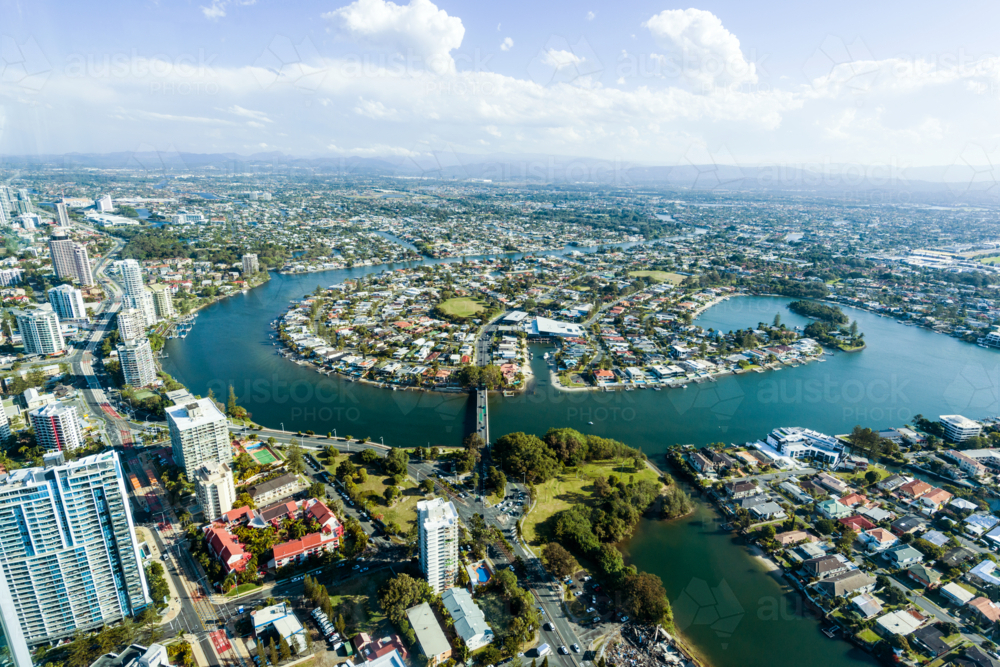 Aerial view of waterfront suburbs and canals in a sprawling coastal city under a clear blue sky. - Australian Stock Image