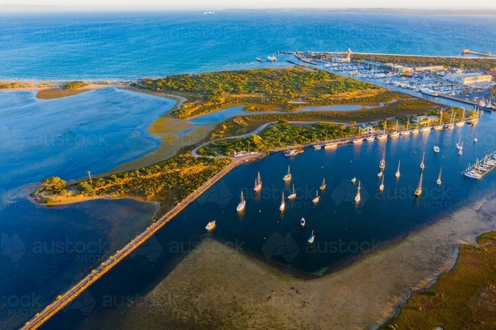 Aerial view of yacht club and marina along side an island and lagoon - Australian Stock Image