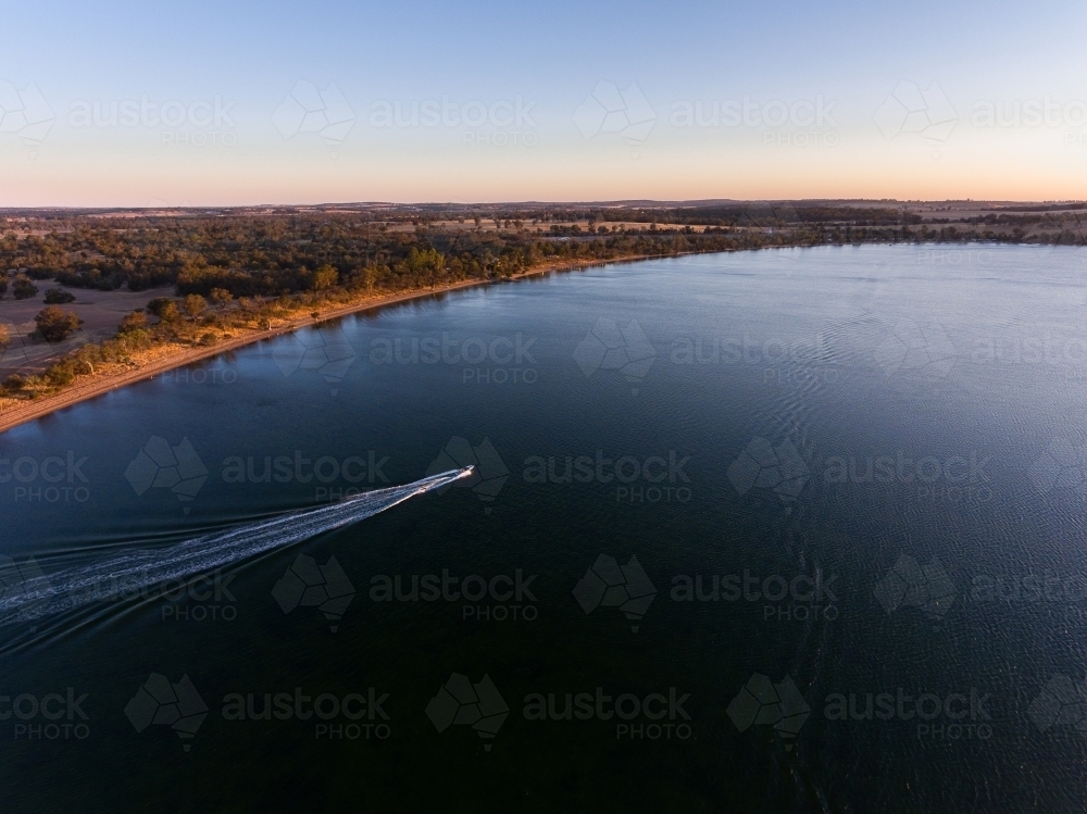 aerial view over Lake Towerrinning with speedboat leaving white wake - Australian Stock Image
