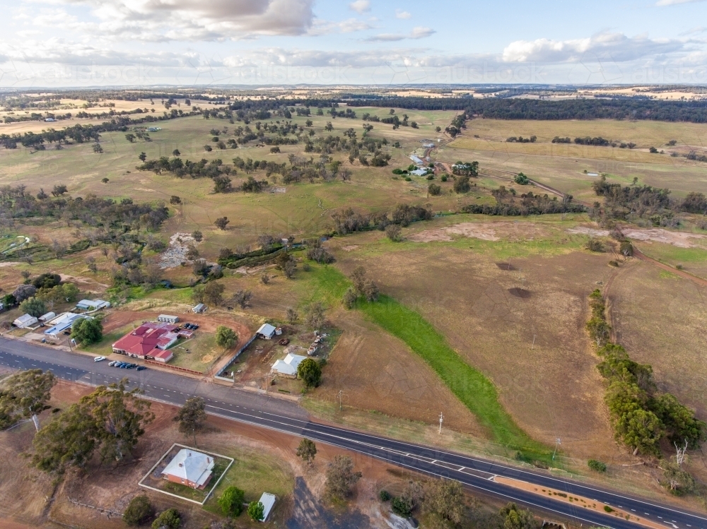 aerial view over outskirts of small town with farmland to the horizon - Australian Stock Image