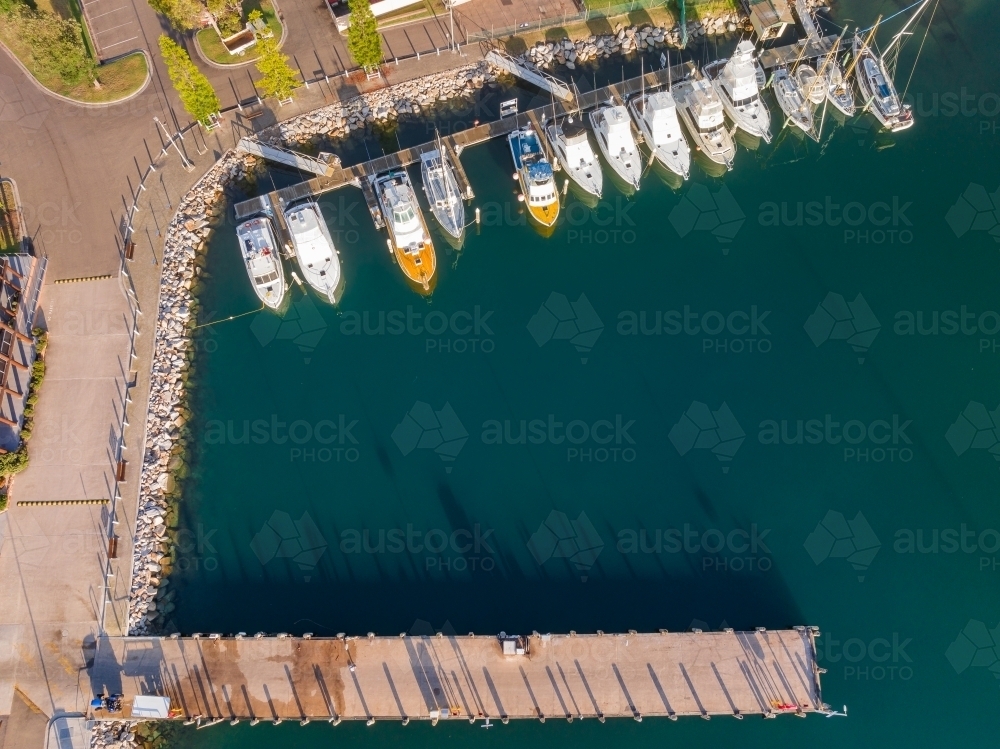 Image of Aerial view over rows of boats moored along a jetty in a ...