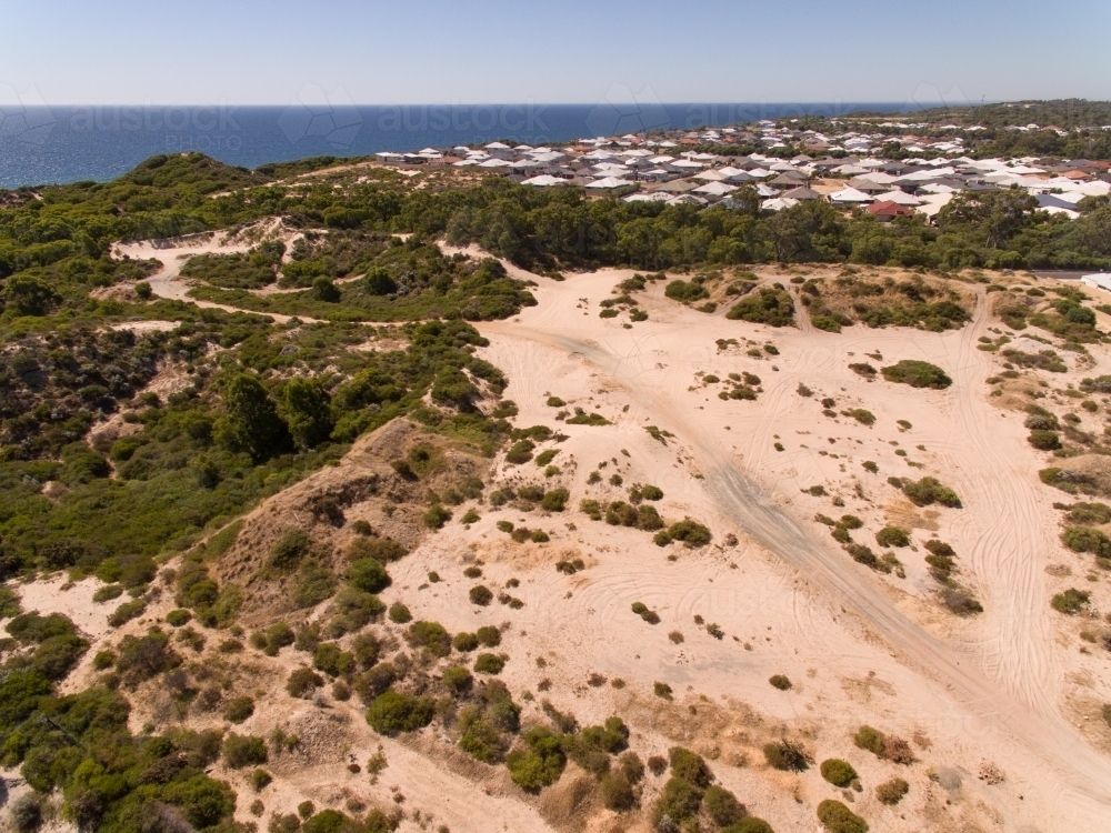 aerial view over sand dune to new housing development - Australian Stock Image