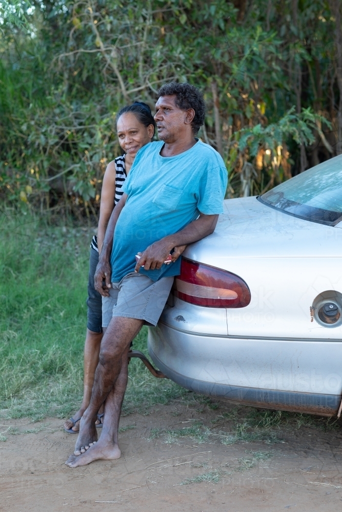 affectionate mature couple leaning on the boot of their car - Australian Stock Image