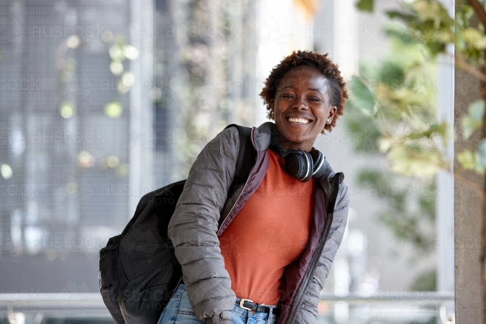 African woman having fun in city with headphones - Australian Stock Image