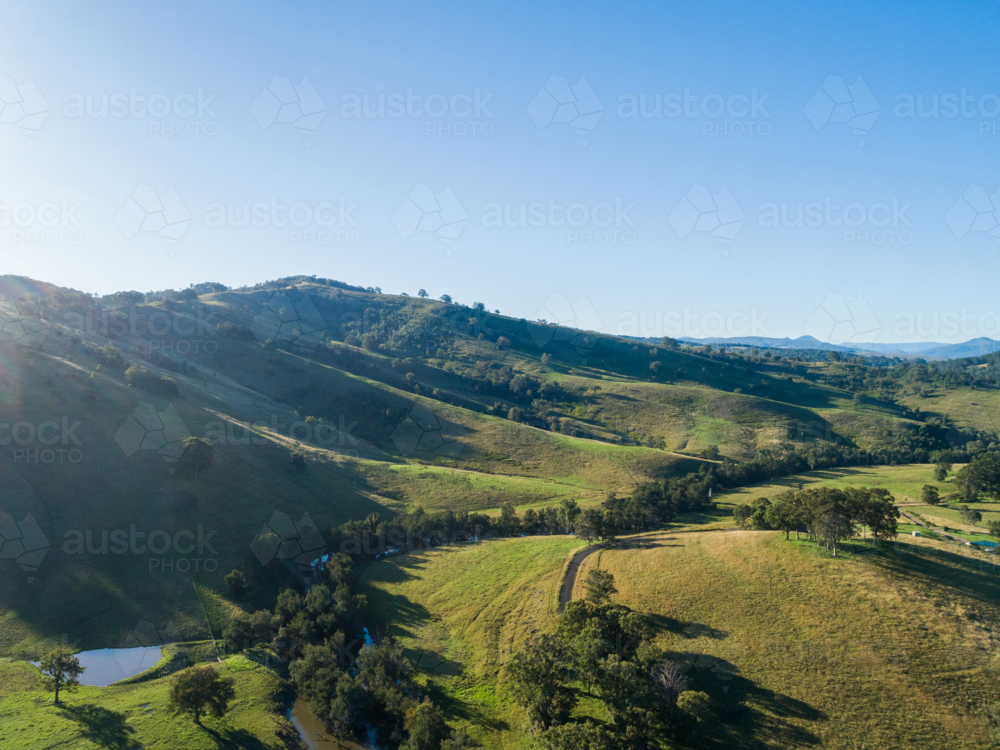 afternoon aerial view of green hilly sunlit St Clair landscape in Hunter Valley, NSW, Australia - Australian Stock Image