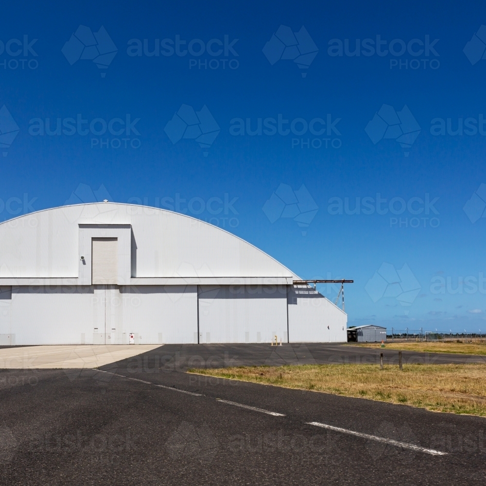 Airplane hangar with rounded top and clear blue sky - Australian Stock Image