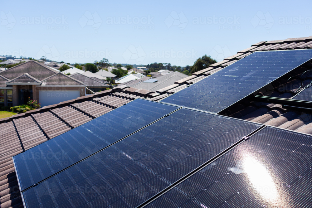 All black bifacial solar panels on roof being installed and connected to power system - Australian Stock Image