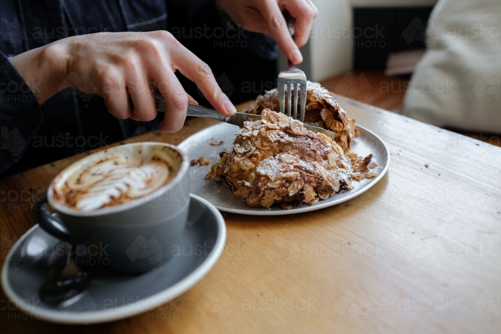 Almond croissant breakfast with cup of coffee - Australian Stock Image