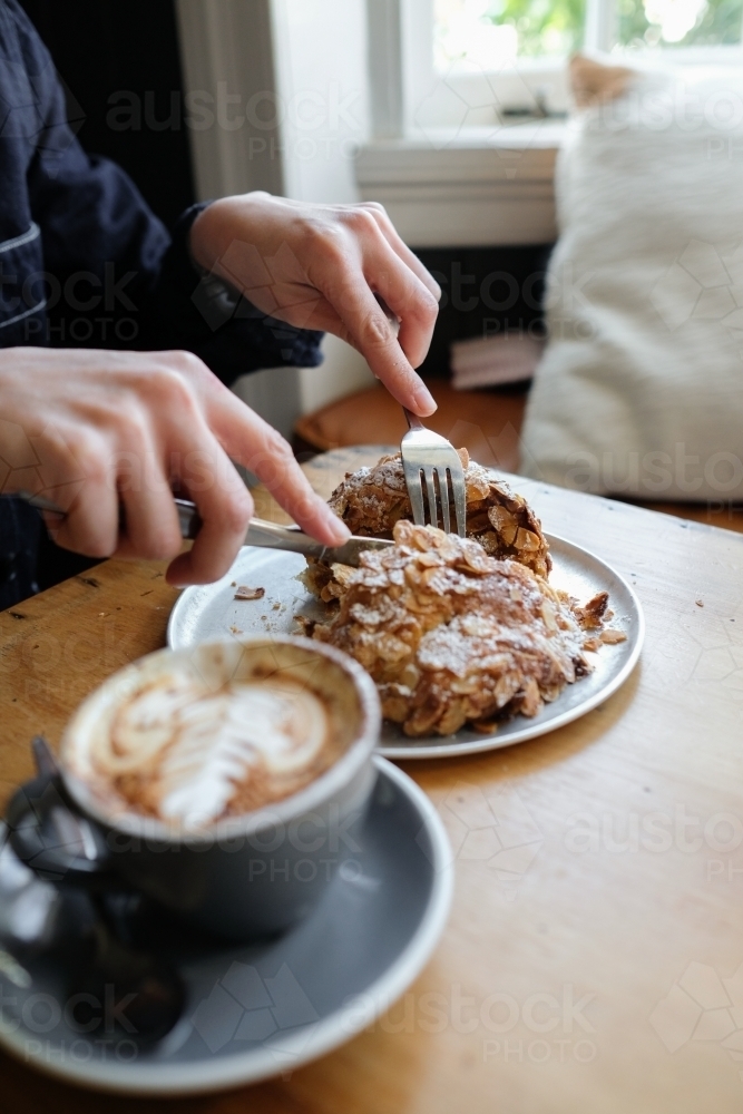 Almond croissant breakfast with cup of coffee - Australian Stock Image