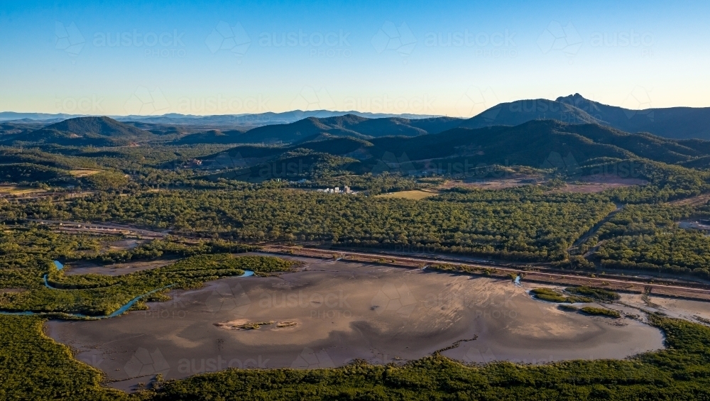 Alumina conveyor belt with mudflats in the foreground and hills in the background - Australian Stock Image