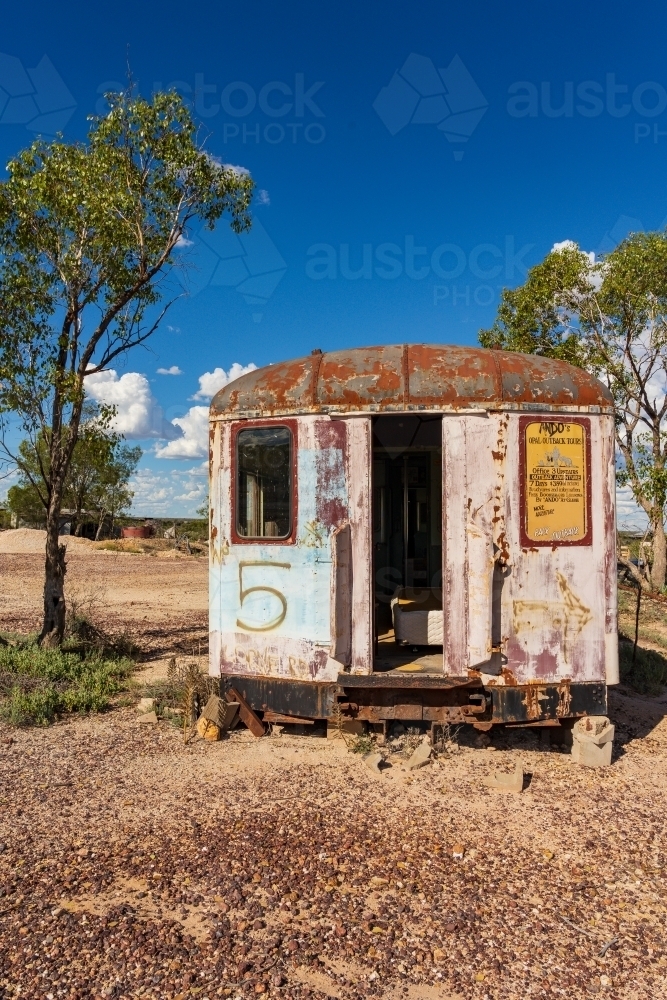 An abandoned railway carriage sitting in an arid outback landscape - Australian Stock Image