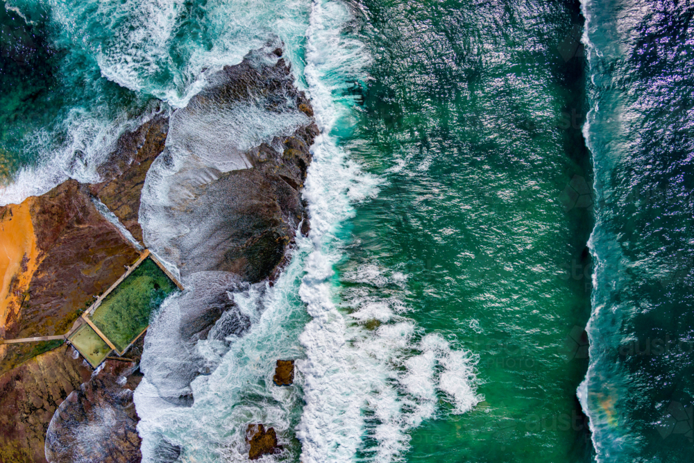 An abstract overhead of the waves crashing onto the rock platform at Mona Vale rock pool - Australian Stock Image