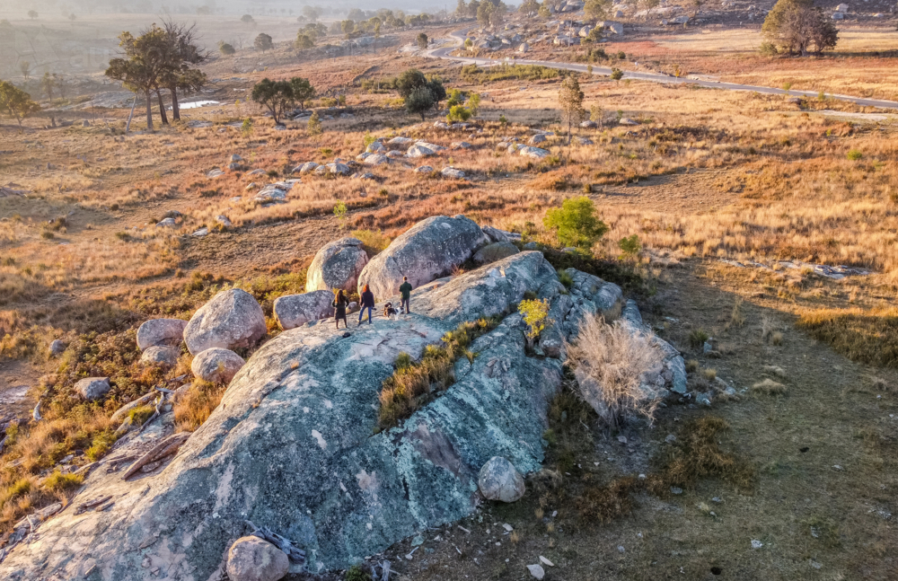An aerial shot of a family standing on a granite rock in the country - Australian Stock Image