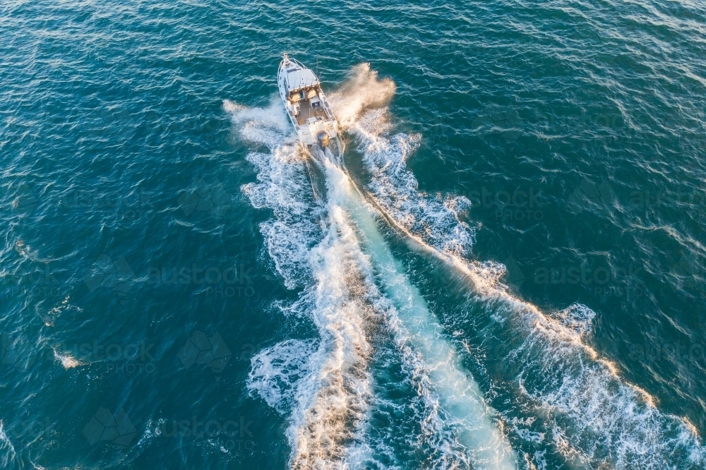 An aerial view of a  small boat crashing through the ocean - Australian Stock Image