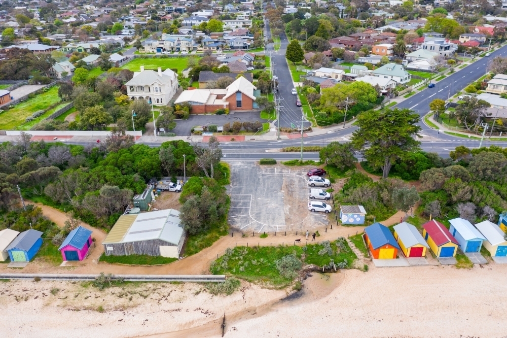 An aerial view of a small coastal car park between rows of brightly colored bathing boxes - Australian Stock Image