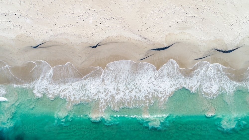 An aerial view of a wave about to crash on the shore - Australian Stock Image