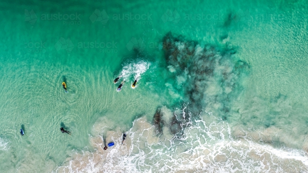 An aerial view of bodyboarders paddling for position - Australian Stock Image