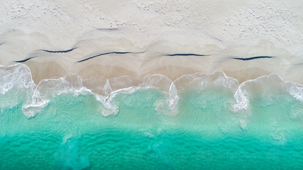 An aerial view of water receeding into the ocean - Australian Stock Image