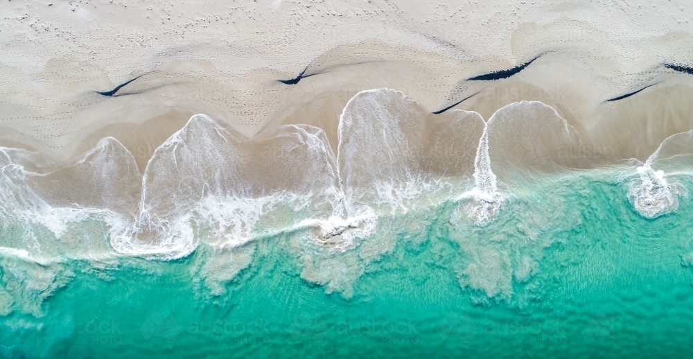 An aerial view of water swirling on the shore - Australian Stock Image