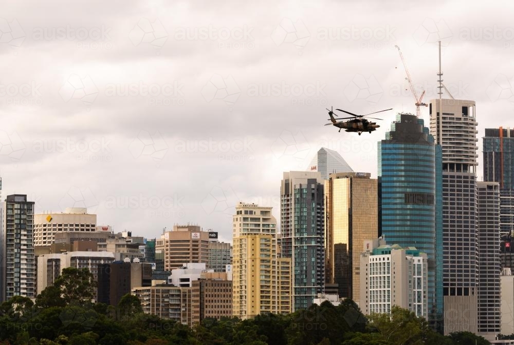 An army helicopter flying over Brisbane central business district during the floods - Australian Stock Image