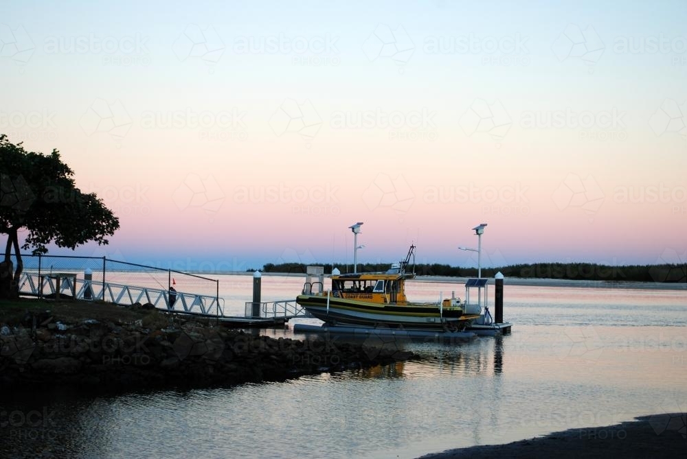 An Australian Volunteer Coast Guard boat is moored in Caloundra at sunset - Australian Stock Image