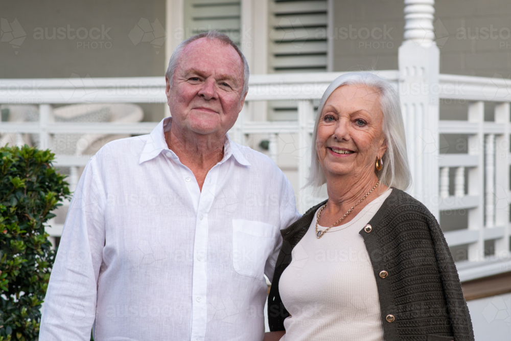Image of An elderly couple outside their home, standing close with ...