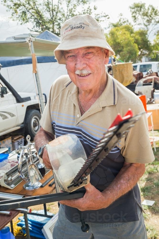 An elderly man holding a hedge trimmer - Australian Stock Image