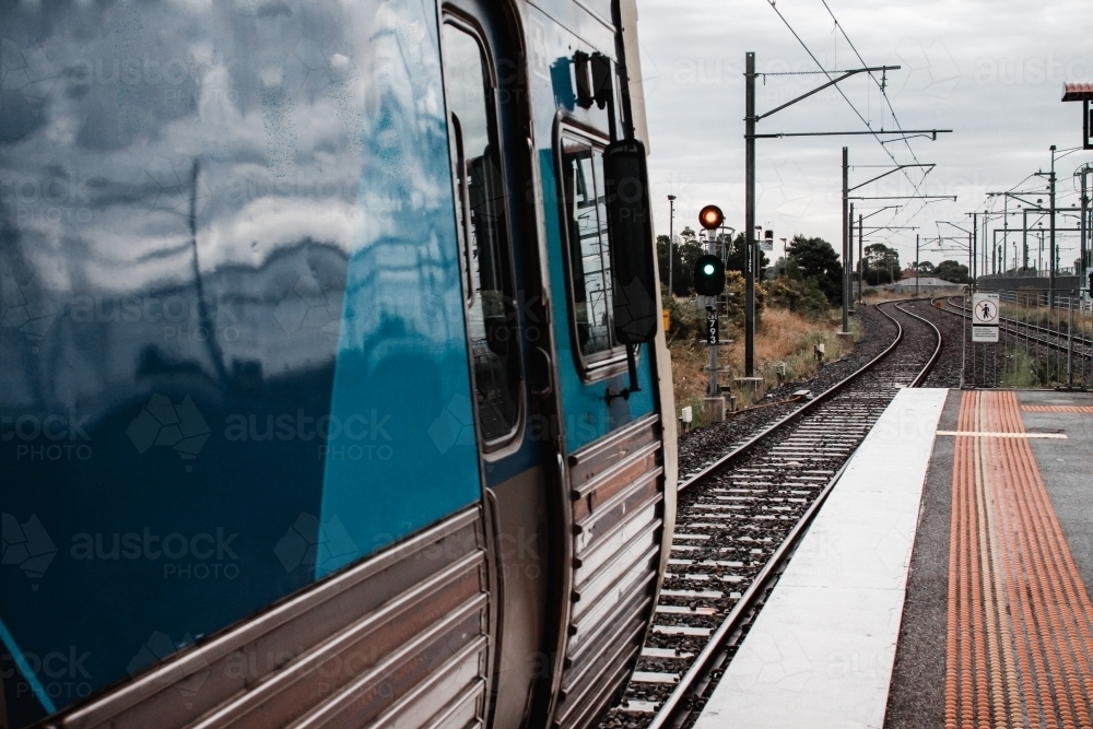 An electric comeng train in Melbourne Australia, sitting at a signal at a station platform - Australian Stock Image