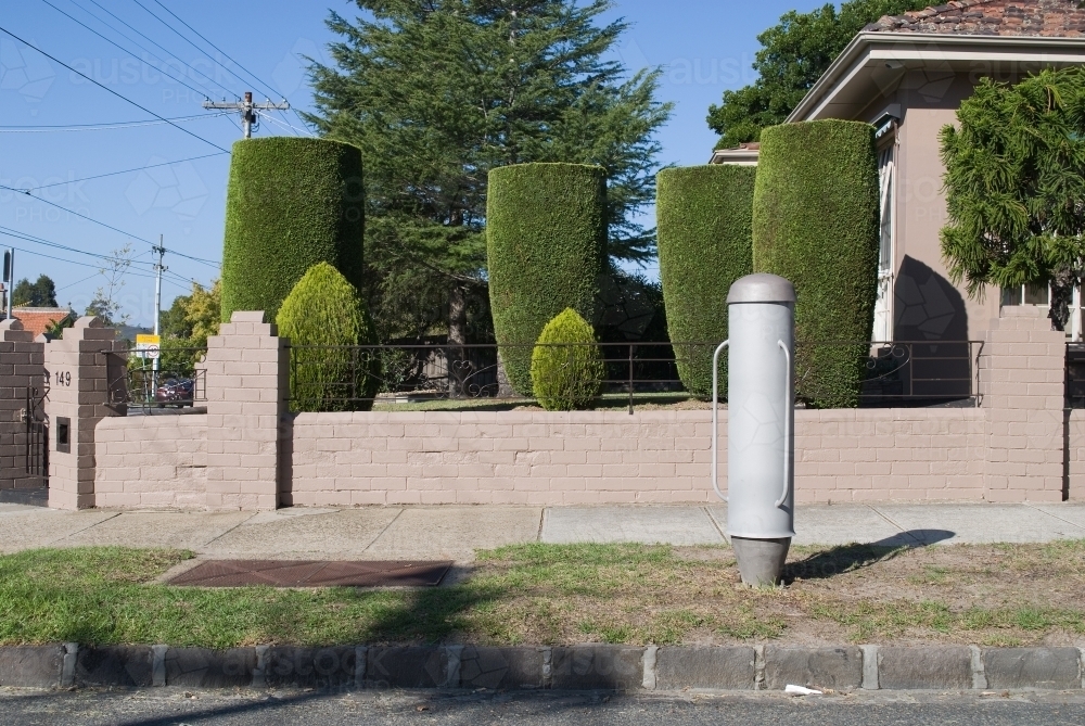 An electrical cylinder outside a garden of similar shaped trees - Australian Stock Image