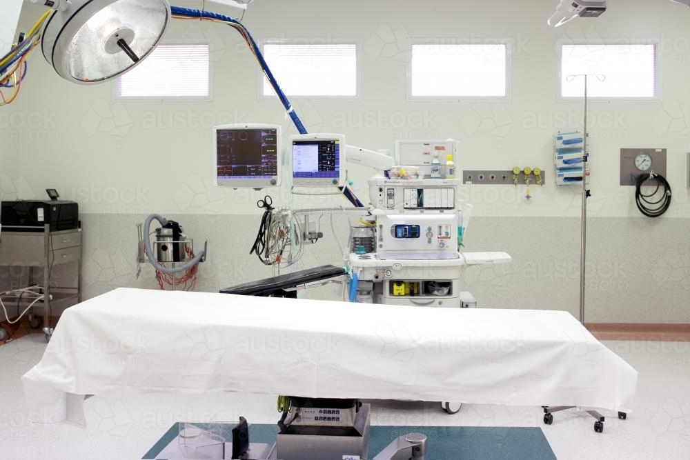 An empty bed with machines in the operating theatre in a hospital - Australian Stock Image