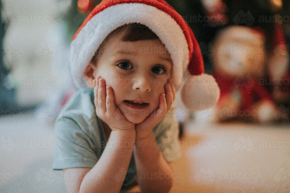 An innocent face and happy boy indoors at Christmas - Australian Stock Image