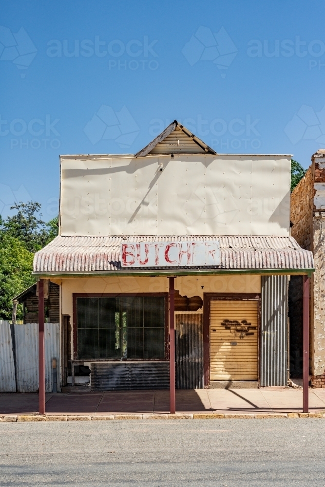 An old abandoned butcher shop with bars over the windows - Australian Stock Image